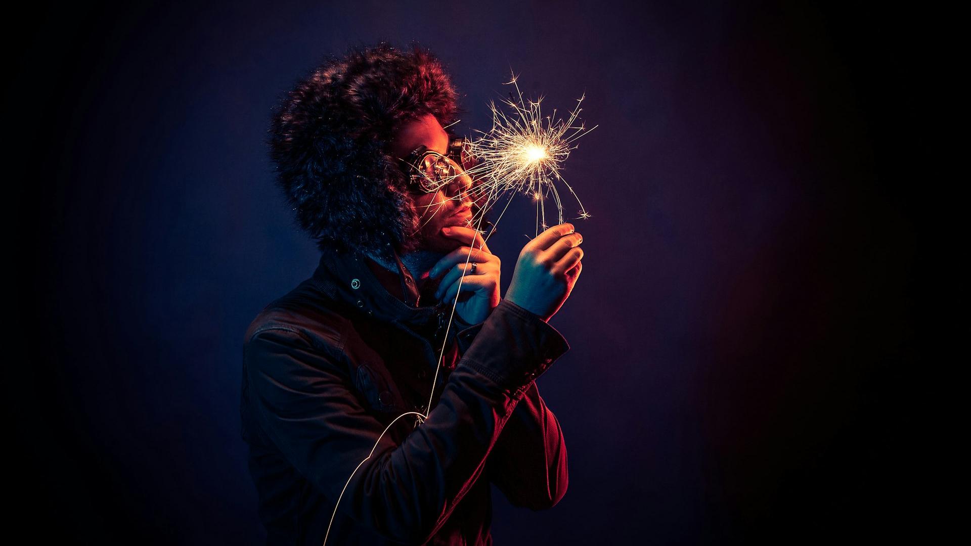 man in black jacket holding spark