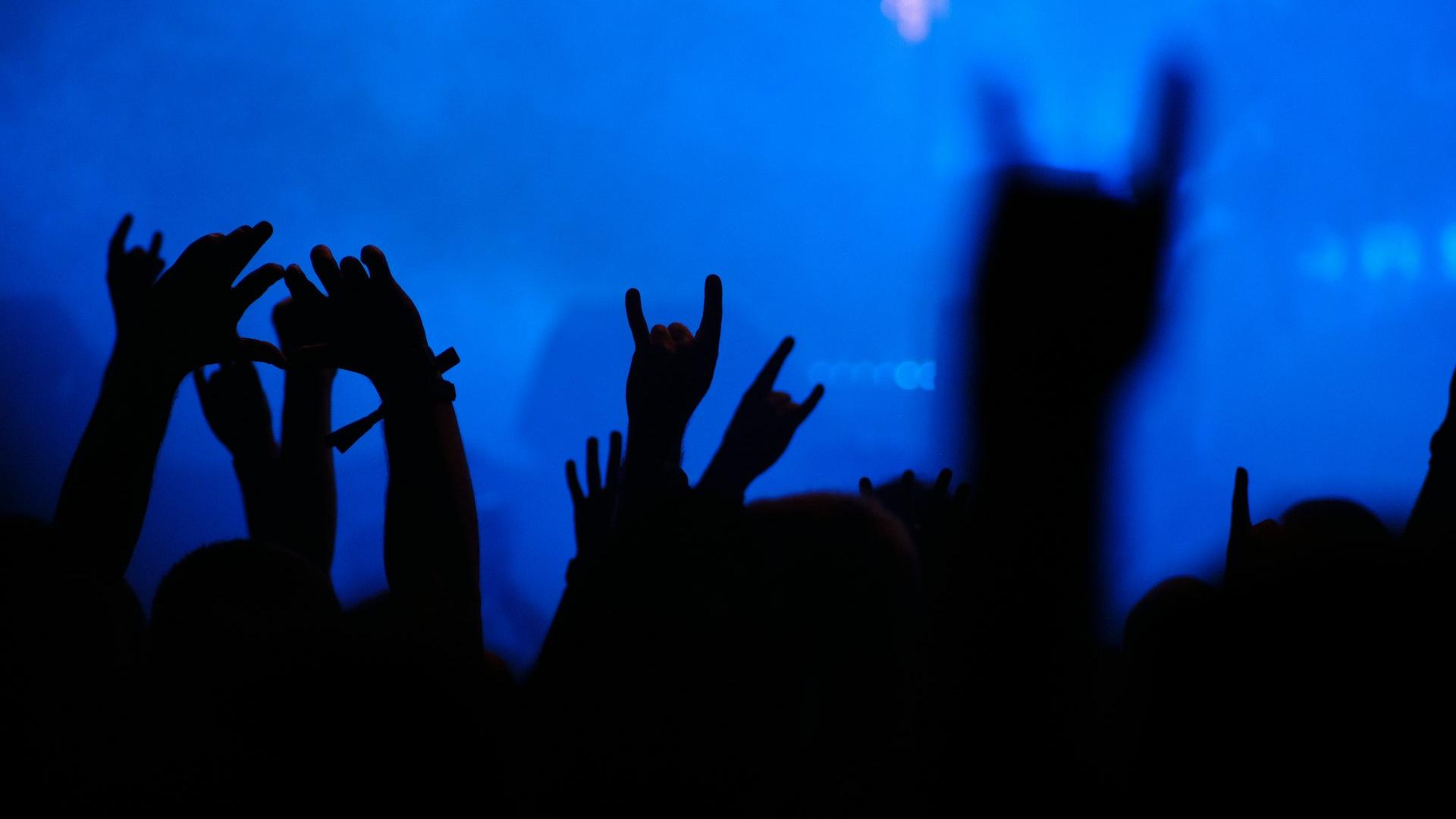 a crowd of people raising their hands in the air